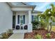 Inviting front porch with blue shutters, wicker chairs, and landscaping at 13589 Old Creek Ct, Parrish, FL 34219