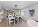 Elegant dining room with white table and blue chairs, hardwood floors at 13756 Vadini St, Venice, FL 34293