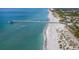 Aerial view of a pier extending into ocean with sandy beach and swimmers at 1579 Waterford Dr, Venice, FL 34292