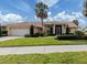 Tan house with tile roof, palm trees, and landscaped yard at 1579 Waterford Dr, Venice, FL 34292