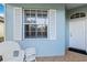 White wicker chairs and side table on a tiled front porch at 1634 Monarch Dr # 1634, Venice, FL 34293