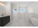 Spa-like bathroom with a freestanding tub, walk-in shower, and marble-look tile at 18055 Dublin Ave, Port Charlotte, FL 33948