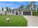 Single-story home with dark gray garage door and well-manicured lawn at 18055 Dublin Ave, Port Charlotte, FL 33948