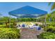 A bocce ball court under a shaded structure with tables and chairs at 1841 Batello Dr, Venice, FL 34292