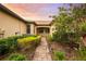 Brick walkway leads to charming villa entrance, surrounded by lush landscaping at 18891 Lanuvio St, Venice, FL 34293
