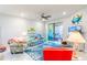 Bright living room with comfy seating, ocean-themed decor, and access to a screened patio at 18891 Lanuvio St, Venice, FL 34293