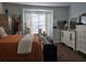 Bedroom with large windows, white dresser, and burnt orange bedding at 1890 San Trovaso Way, Venice, FL 34285