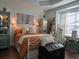 Spacious bedroom with a burnt orange comforter, large windows, and decorative cabinets at 1890 San Trovaso Way, Venice, FL 34285