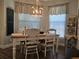 Bright dining room with a farmhouse table and chandelier, near two windows at 1890 San Trovaso Way, Venice, FL 34285