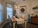 Farmhouse-style dining room featuring a rustic wooden table, chandelier, and decorative wall accents at 1890 San Trovaso Way, Venice, FL 34285