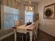 Farmhouse-style dining room featuring a rustic wooden table, chandelier, and decorative wall accents at 1890 San Trovaso Way, Venice, FL 34285