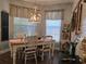 Bright dining room with farmhouse table and chandelier, near two windows at 1890 San Trovaso Way, Venice, FL 34285