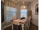 Farmhouse-style dining room with rustic wooden table, chandelier, and decorative wall accents at 1890 San Trovaso Way, Venice, FL 34285