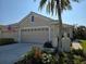 Two-car garage, tan house with palm tree at 1890 San Trovaso Way, Venice, FL 34285
