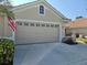 Tan house with a two-car garage and American flag at 1890 San Trovaso Way, Venice, FL 34285