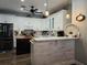 Modern kitchen boasts white cabinets, a kitchen island, and stainless steel appliances at 1890 San Trovaso Way, Venice, FL 34285