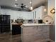 Modern kitchen boasts white cabinets, a kitchen island, and stainless steel appliances at 1890 San Trovaso Way, Venice, FL 34285