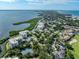 Aerial view of waterfront community with lush landscaping, tennis courts, and bay views at 2020 Harbourside Dr # 424, Longboat Key, FL 34228