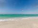 Scenic beach view with calm water, white sand, and a bird in flight at 2020 Harbourside Dr # 424, Longboat Key, FL 34228