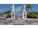Entrance to Sarasota Bayfront, featuring a decorative archway and palm trees at 2020 Harbourside Dr # 424, Longboat Key, FL 34228