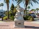 Statue of Neptune in a landscaped area with palm trees and nearby shops at 2020 Harbourside Dr # 424, Longboat Key, FL 34228