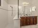 Bathroom with double vanity, large mirror, and a walk-in shower at 205 Carlino Dr, Nokomis, FL 34275