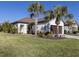 Single-story home with tile roof, two palm trees, and a well-manicured lawn at 205 Carlino Dr, Nokomis, FL 34275