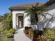 Front entryway with brown door and lush landscaping at 205 Carlino Dr, Nokomis, FL 34275