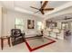 Living room boasts a ceiling fan, comfy seating, and views into the kitchen at 205 Carlino Dr, Nokomis, FL 34275