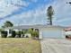 Single-story house with white exterior, gray roof, and a two-car garage at 212 San Carlos Ave, North Port, FL 34287