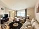 Living room featuring a neutral color scheme, plush sofas, and a large flat-screen TV at 212 San Carlos Ave, North Port, FL 34287