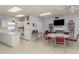 Community room with kitchen, tables, chairs, and bookcases at 214 Field E Ave # 1, Venice, FL 34285
