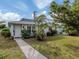 Light-blue house with a walkway, palm trees, and lush green lawn at 214 Field E Ave # 1, Venice, FL 34285