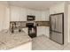 Kitchen with granite countertops, white cabinets, and stainless steel appliances at 214 Field E Ave # 1, Venice, FL 34285