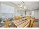 Dining room features a wood table, chairs, and striped tablecloth, hardwood floors, and a chandelier at 23253 Banbury Way, Venice, FL 34293