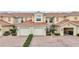 Tan two-story condo with two-car garage and landscaping at 23253 Banbury Way, Venice, FL 34293