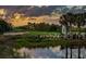 Scenic golf course with water features and palm trees at sunset at 23253 Banbury Way, Venice, FL 34293