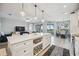 Open concept kitchen with white cabinets, large island, and stainless steel appliances at 23253 Banbury Way, Venice, FL 34293