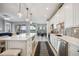 Modern kitchen with white cabinets, stainless steel appliances and an island with wine storage at 23253 Banbury Way, Venice, FL 34293