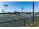 Well-lit tennis courts with surrounding fencing at 23253 Banbury Way, Venice, FL 34293