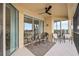 A screened-in balcony with white tile flooring and a ceiling fan provides scenic water views at 23253 Banbury Way, Venice, FL 34293