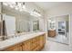 Bathroom featuring double sinks, a large mirror, and plenty of cabinet space at 23253 Banbury Way, Venice, FL 34293