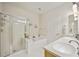 Bright bathroom with a glass-enclosed shower, soaking tub, and double sinks at 23253 Banbury Way, Venice, FL 34293