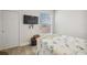 Clean bedroom featuring a window, TV, and light wood flooring at 23253 Banbury Way, Venice, FL 34293