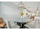 Bright dining area with a glass table, stylish chandelier, and barstool seating with comfortable chairs at 23253 Banbury Way, Venice, FL 34293