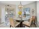 Bright dining area with a glass table, stylish chandelier, and sliding doors to the outdoor balcony at 23253 Banbury Way, Venice, FL 34293