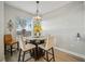 Inviting dining area with a modern chandelier, glass table, and comfortable seating for casual meals at 23253 Banbury Way, Venice, FL 34293