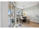Bright dining area with glass table, modern lighting, and access to a balcony with scenic views at 23253 Banbury Way, Venice, FL 34293