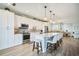 Modern kitchen featuring white cabinetry, stainless steel appliances, and a spacious center island with barstool seating at 23253 Banbury Way, Venice, FL 34293