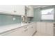 Updated kitchen with white cabinets, granite counters, and light blue backsplash at 244 Saint Augustine Ave # 107, Venice, FL 34285